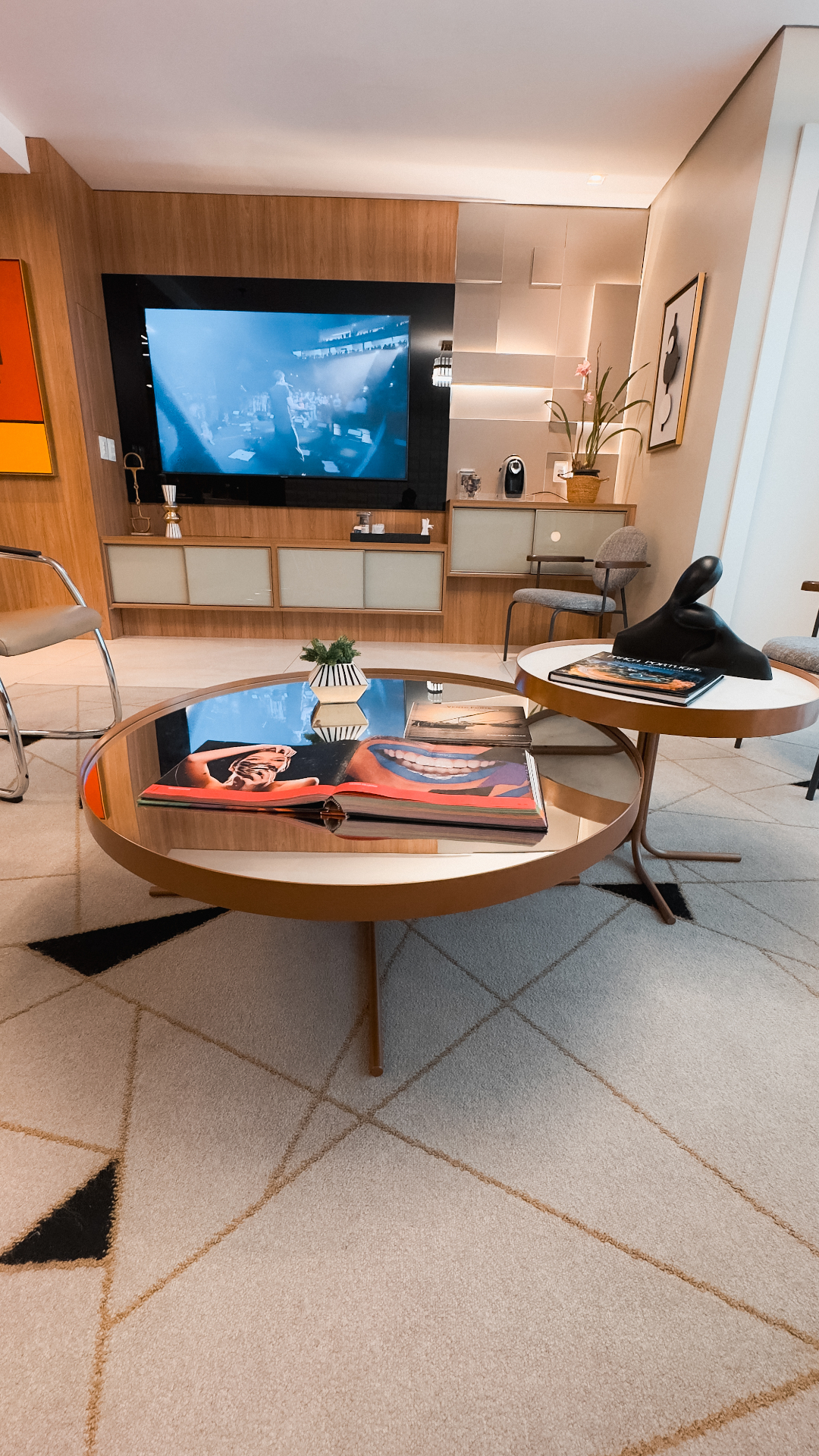 Sala de estar da Conexa Odontologia Conceito com TV e poltronas